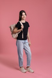 Photo of Cute teenage girl with backpack on pink background