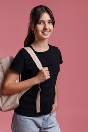 Photo of Portrait of cute teenage girl with backpack on pink background