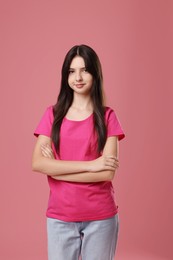 Portrait of cute teenage girl on pink background