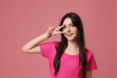 Portrait of cheerful teenage girl on pink background