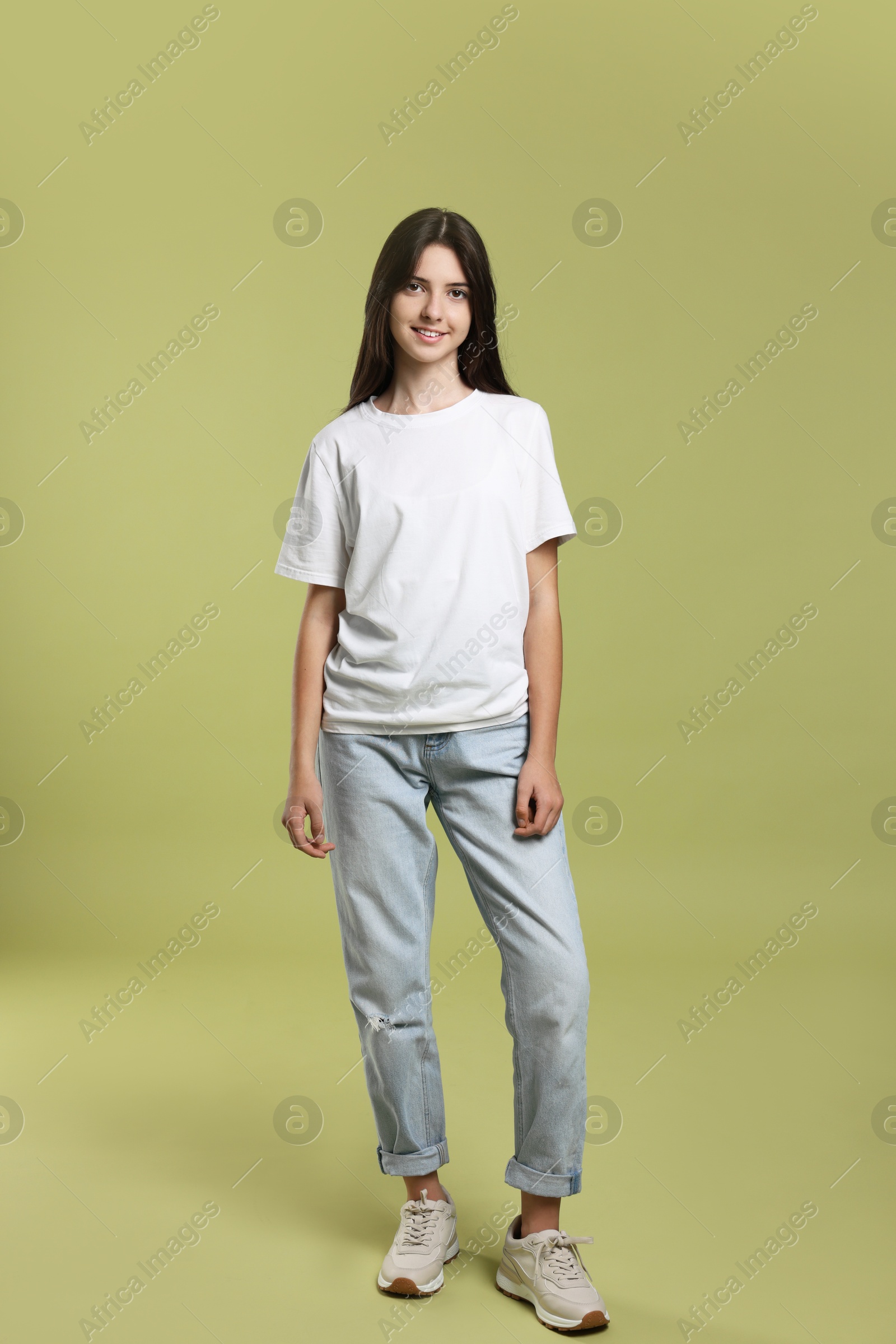 Photo of Full length portrait of cute teenage girl on olive background