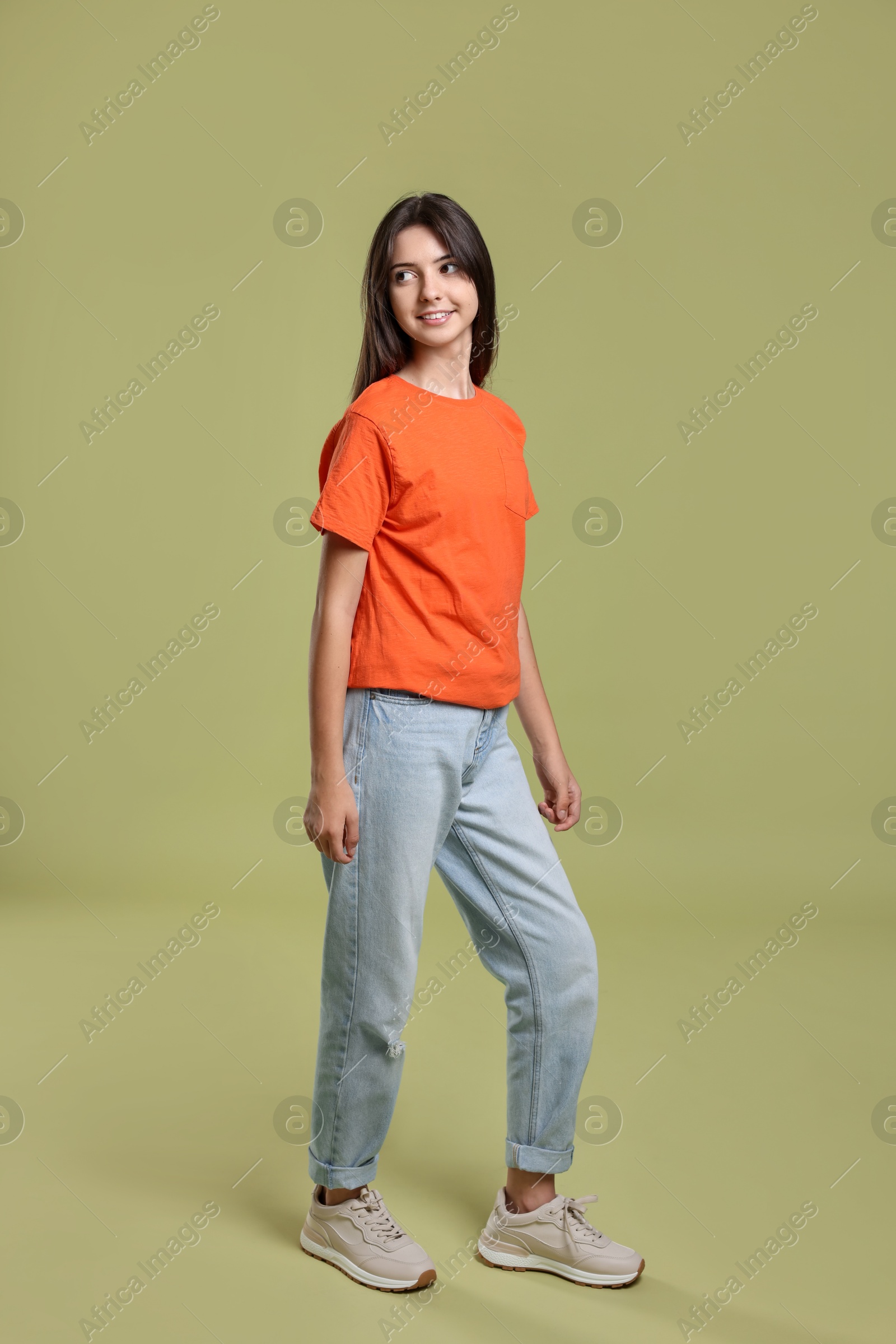 Photo of Full length portrait of cute teenage girl on olive background