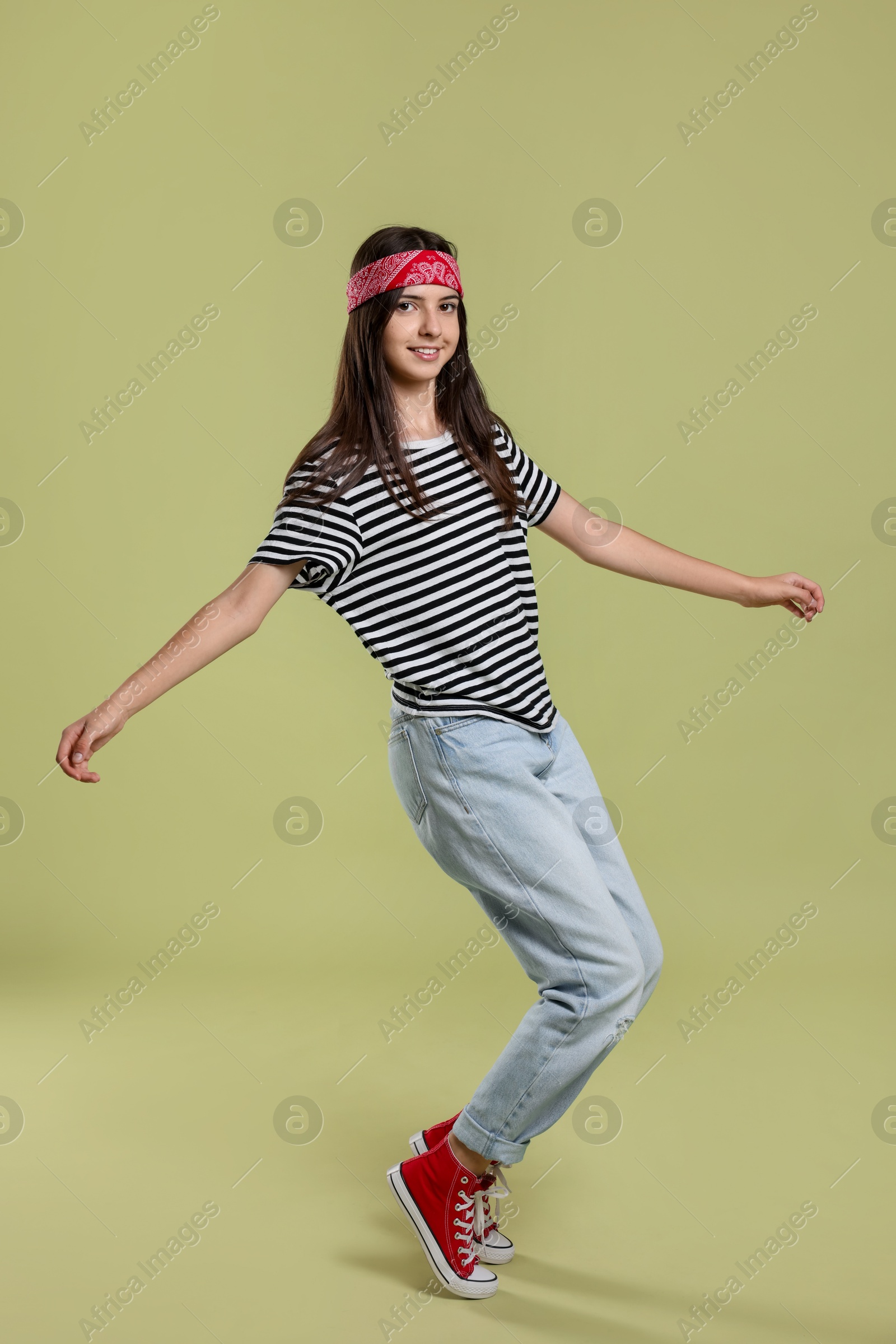 Photo of Full length portrait of cheerful teenage girl on olive background