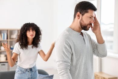 Photo of Emotional couple having quarrel at home, selective focus. Relationship problems