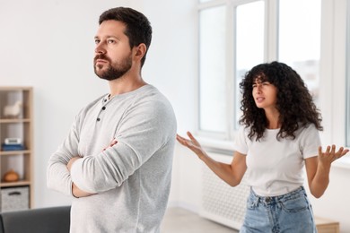 Photo of Emotional couple having quarrel at home, selective focus. Relationship problems