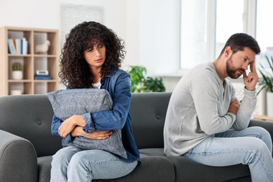 Emotional couple having quarrel on sofa at home. Relationship problems