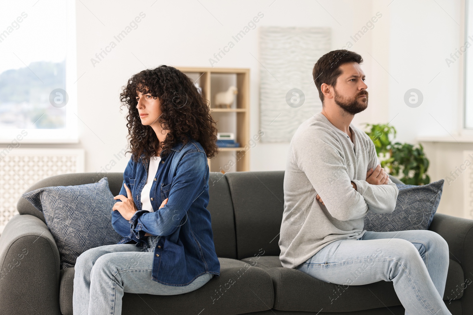 Photo of Emotional couple having quarrel on sofa at home. Relationship problems