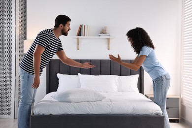 Photo of Emotional couple arguing in bedroom. Relationship problems