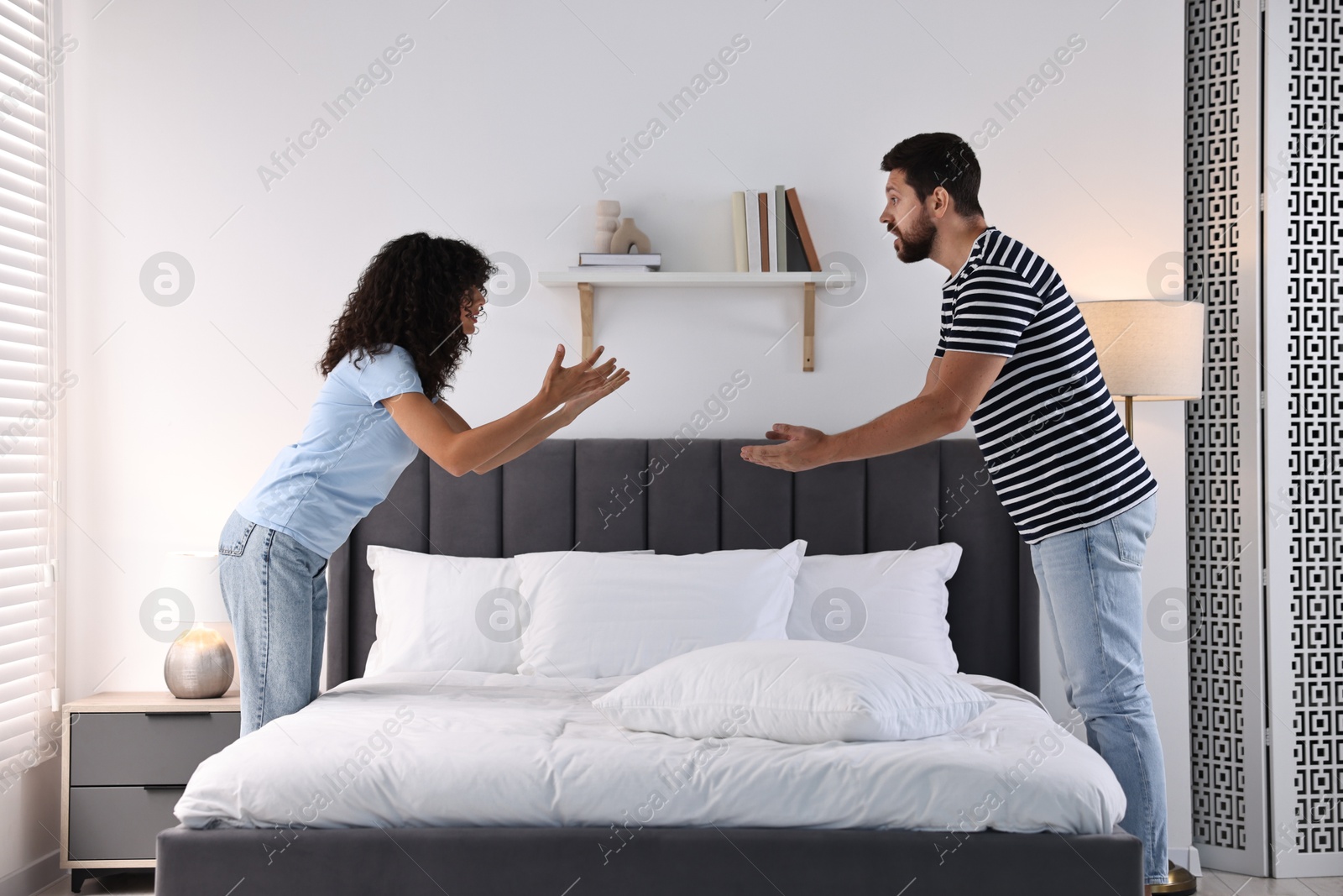 Photo of Emotional couple arguing in bedroom. Relationship problems