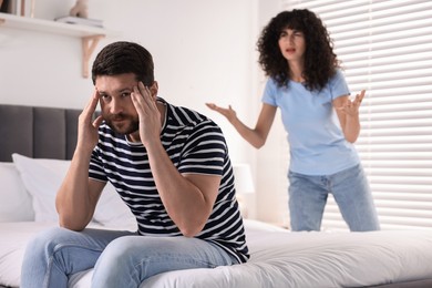 Photo of Emotional couple having quarrel in bedroom, selective focus. Relationship problems