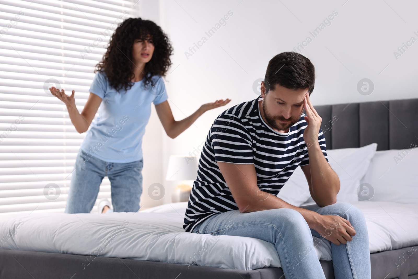 Photo of Emotional couple having quarrel in bedroom, selective focus. Relationship problems