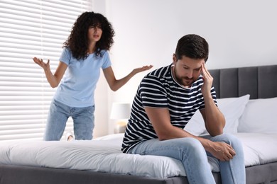 Photo of Emotional couple having quarrel in bedroom, selective focus. Relationship problems