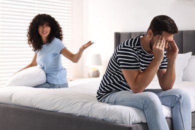 Photo of Emotional couple having quarrel in bedroom, selective focus. Relationship problems