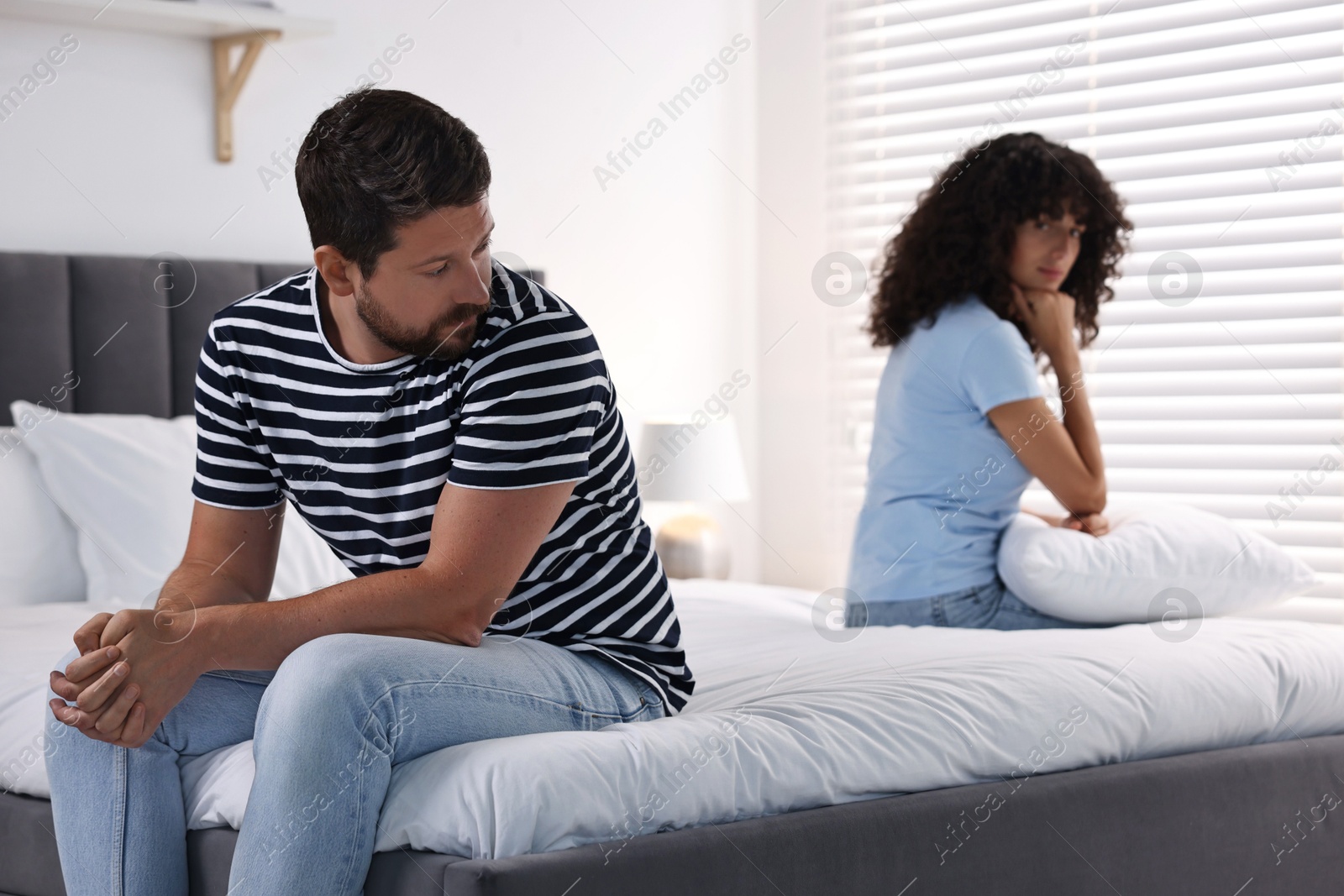 Photo of Couple having quarrel in bedroom, selective focus. Relationship problems