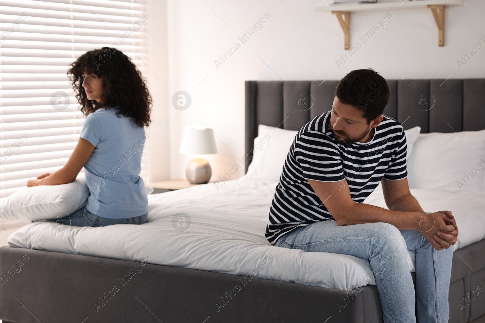 Photo of Couple having quarrel in bedroom, selective focus. Relationship problems