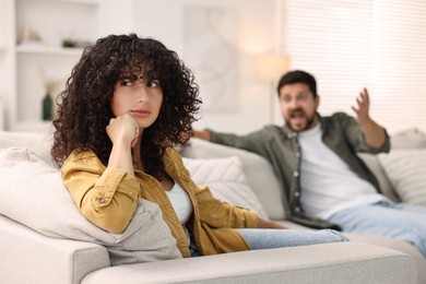 Photo of Couple having quarrel on sofa at home, selective focus. Relationship problems