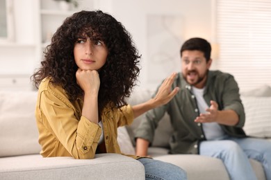 Photo of Couple having quarrel on sofa at home, selective focus. Relationship problems