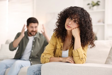 Photo of Couple having quarrel on sofa at home, selective focus. Relationship problems