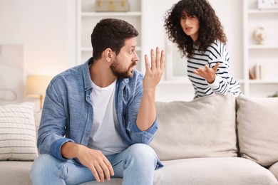 Photo of Emotional couple arguing at home, selective focus. Relationship problems