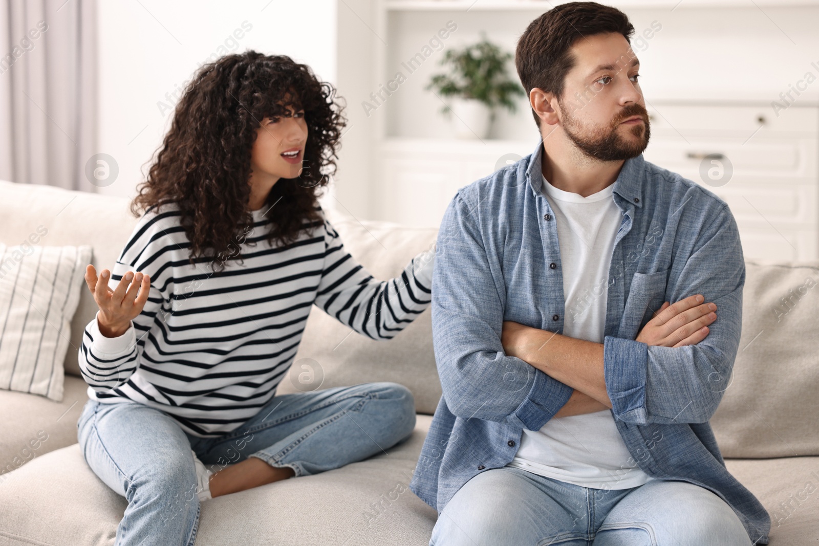 Photo of Emotional couple arguing on sofa at home. Relationship problems