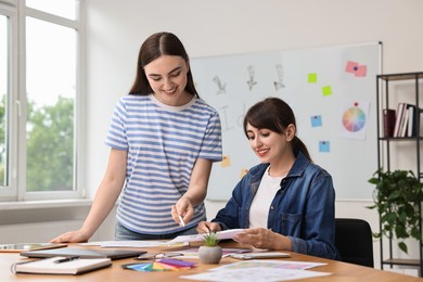 Happy young designers working together in office