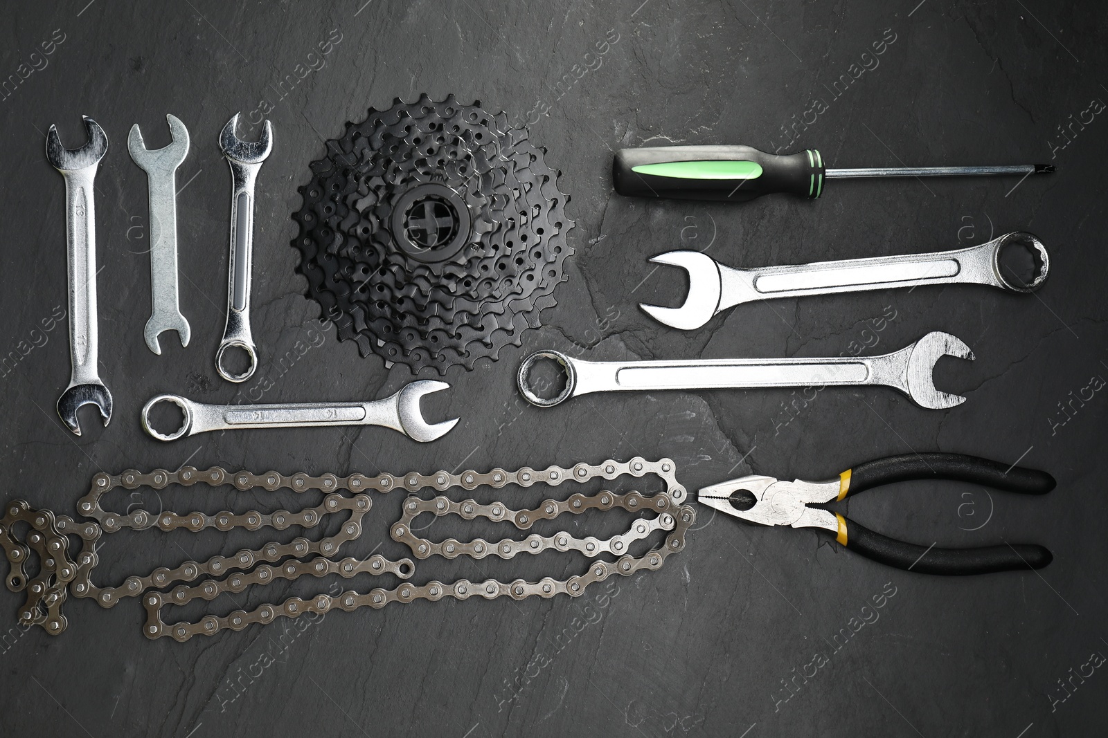 Photo of Parts of bicycle and tools on black table, flat lay