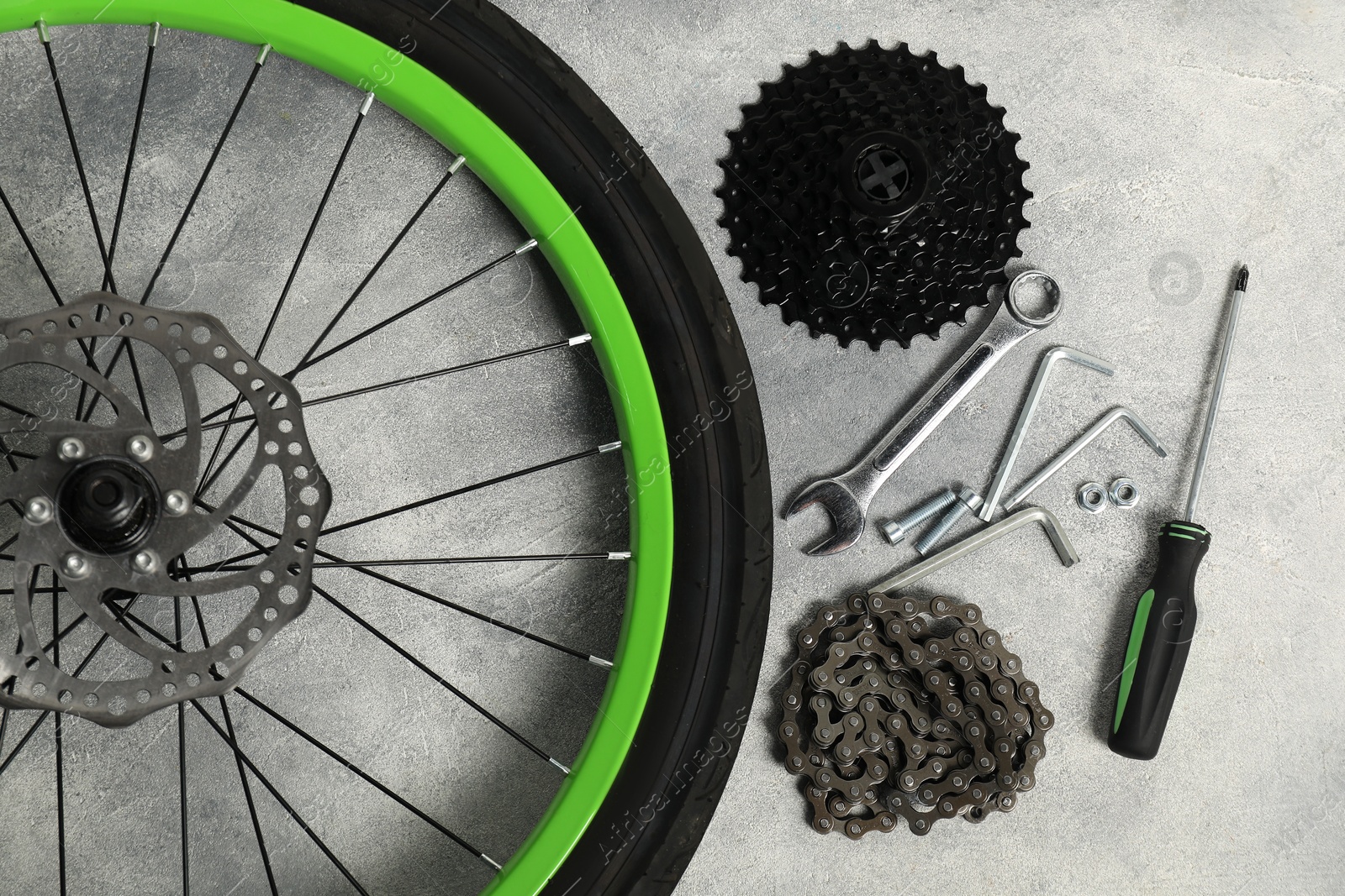 Photo of Parts of bicycle and tools on grey background, flat lay