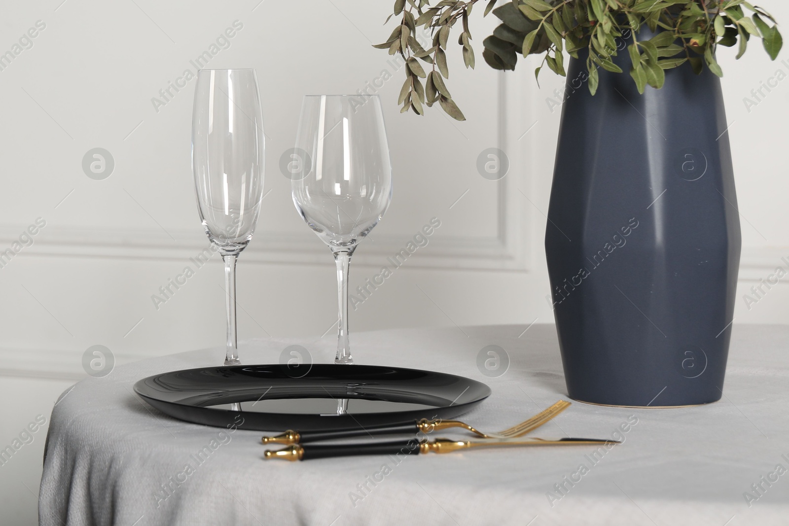 Photo of Stylish table setting with black dishware in dining room