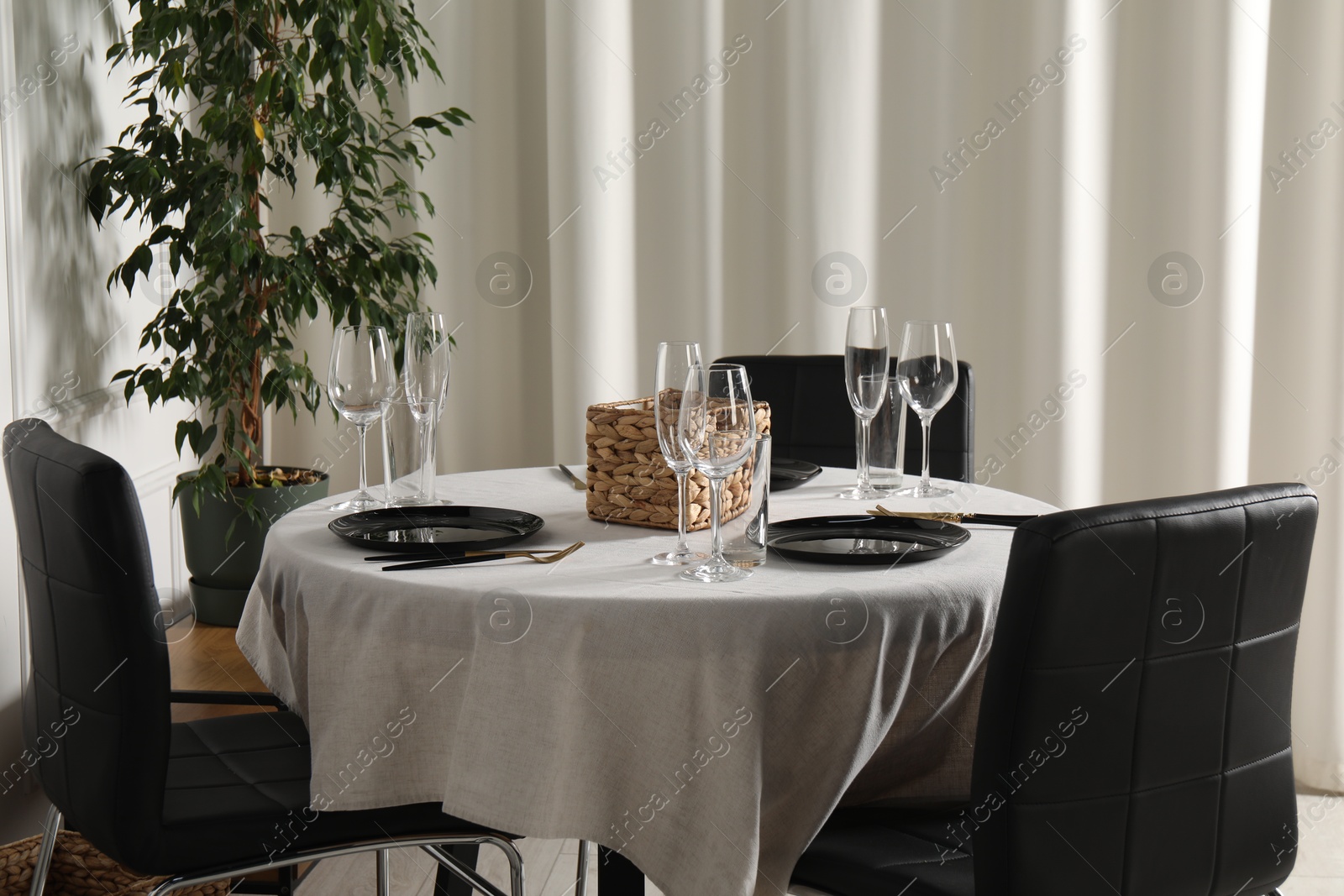 Photo of Stylish table setting with beautiful dishware and black chairs in dining room