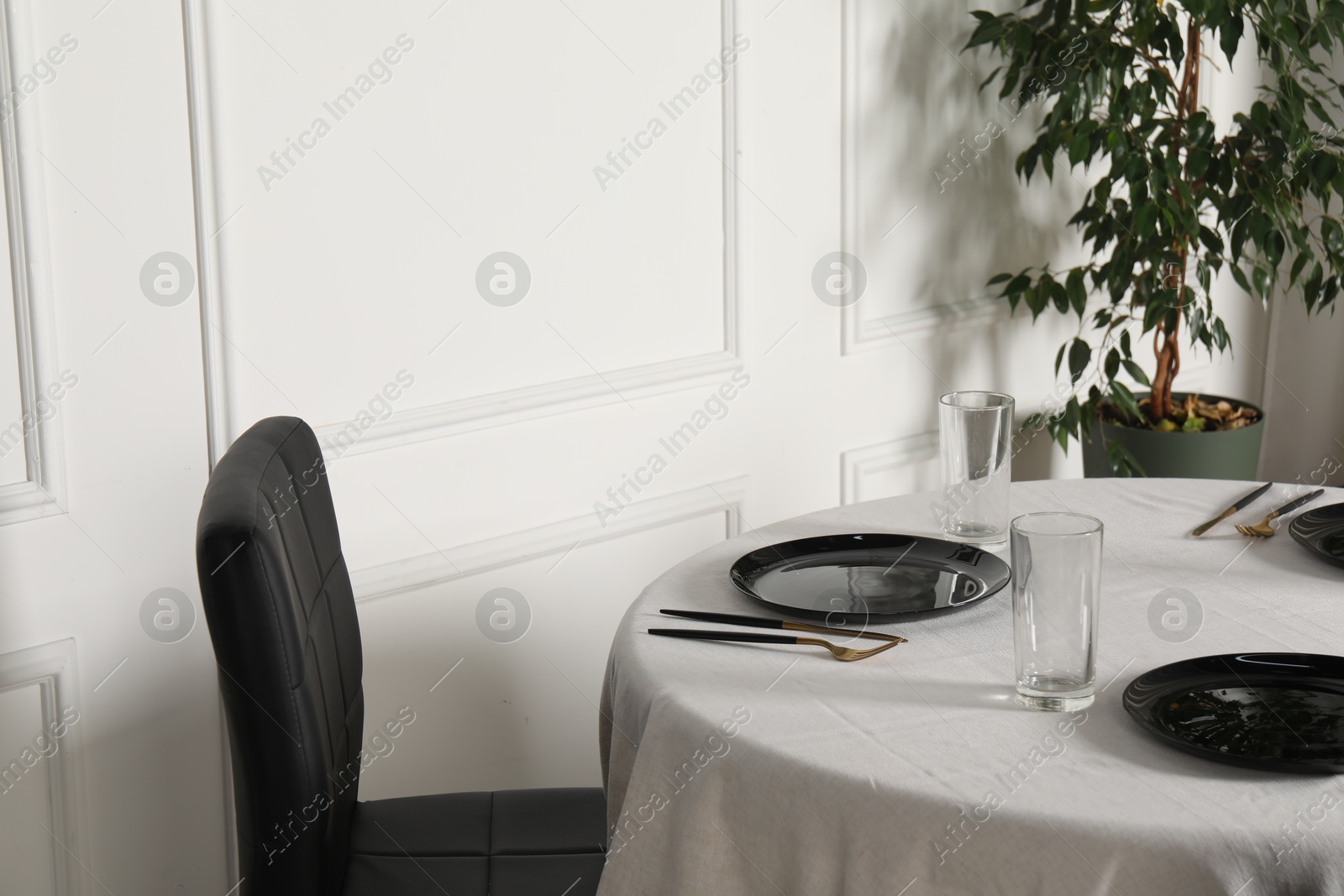 Photo of Stylish table setting with black dishware in dining room