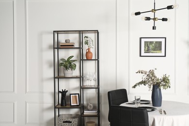 Photo of Stylish table setting with beautiful dishware and black chairs in dining room