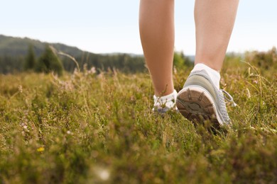 Photo of Woman hiking in mountains, closeup. Space for text