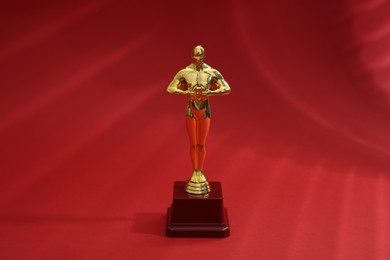 Photo of One golden Oscar award on red background