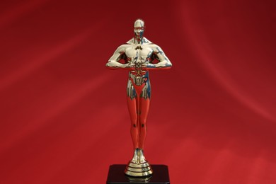 One golden Oscar award on red background