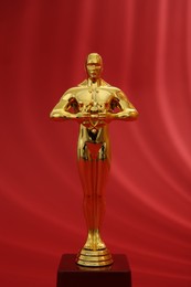 Photo of One golden Oscar award on red background