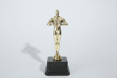 Photo of One golden Oscar award on light background