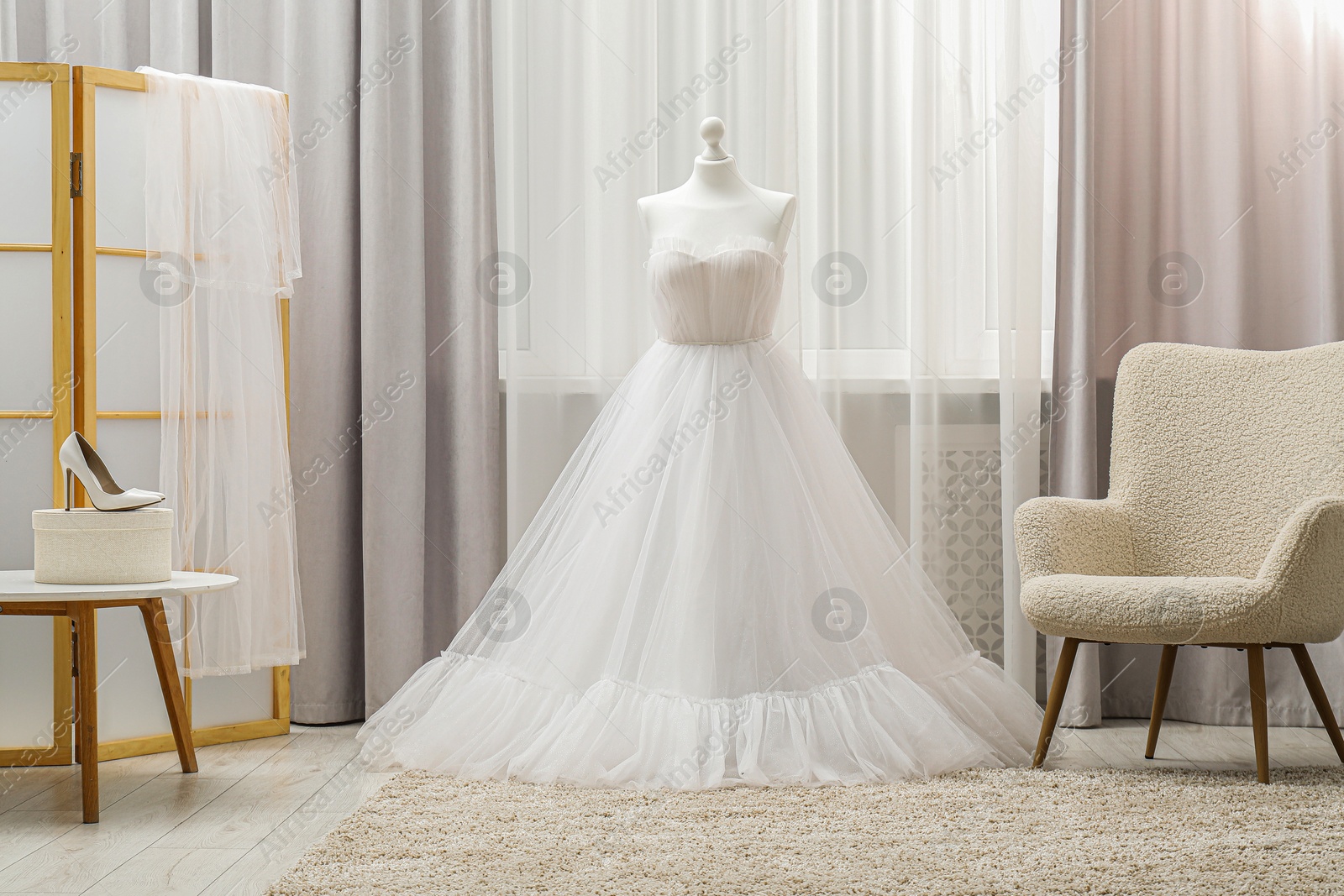 Photo of Beautiful wedding dress on mannequin and shoes in boutique