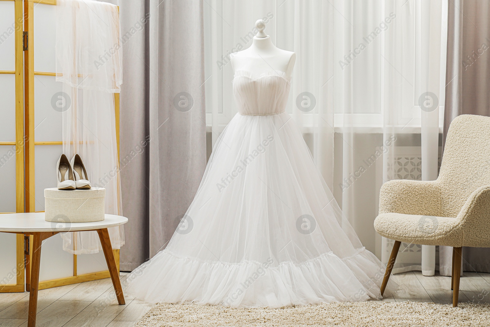 Photo of Beautiful wedding dress on mannequin and shoes in boutique