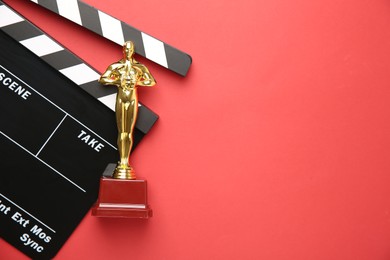 Photo of Golden Oscar award and movie clapper on red background, top view. Space for text