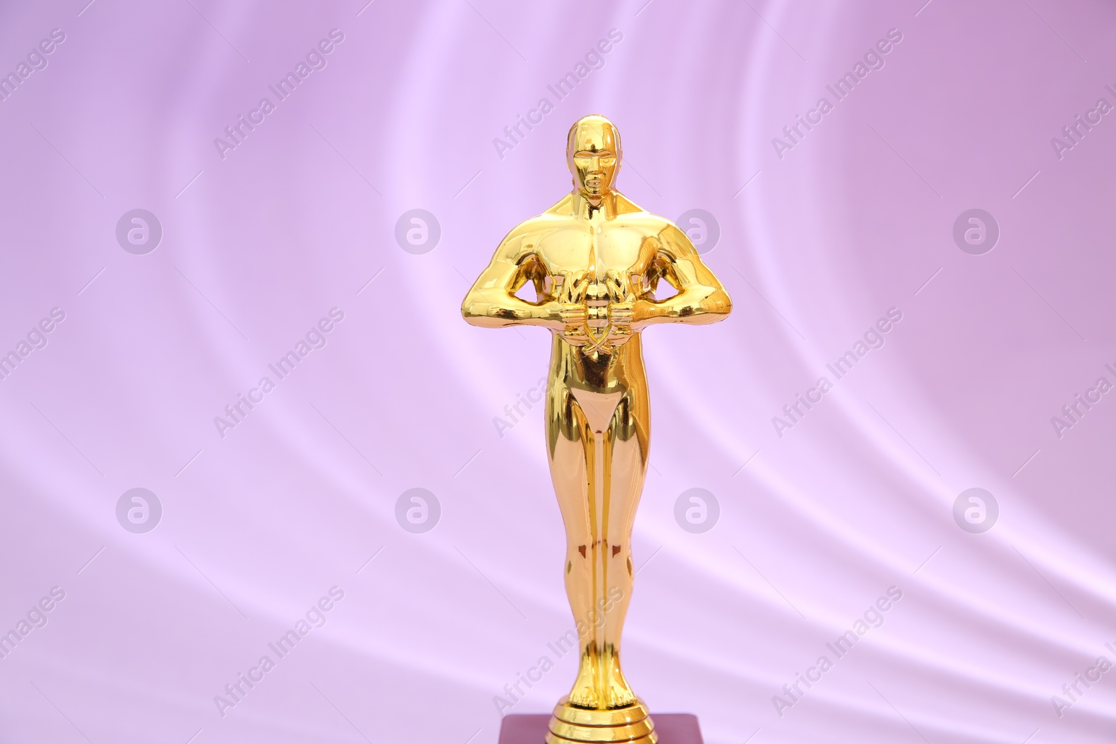 Photo of One golden Oscar award on violet background