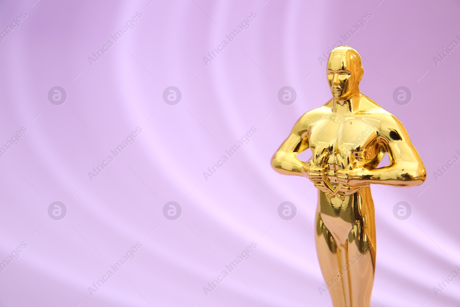 Photo of One golden Oscar award on violet background, space for text