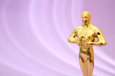 One golden Oscar award on violet background, space for text