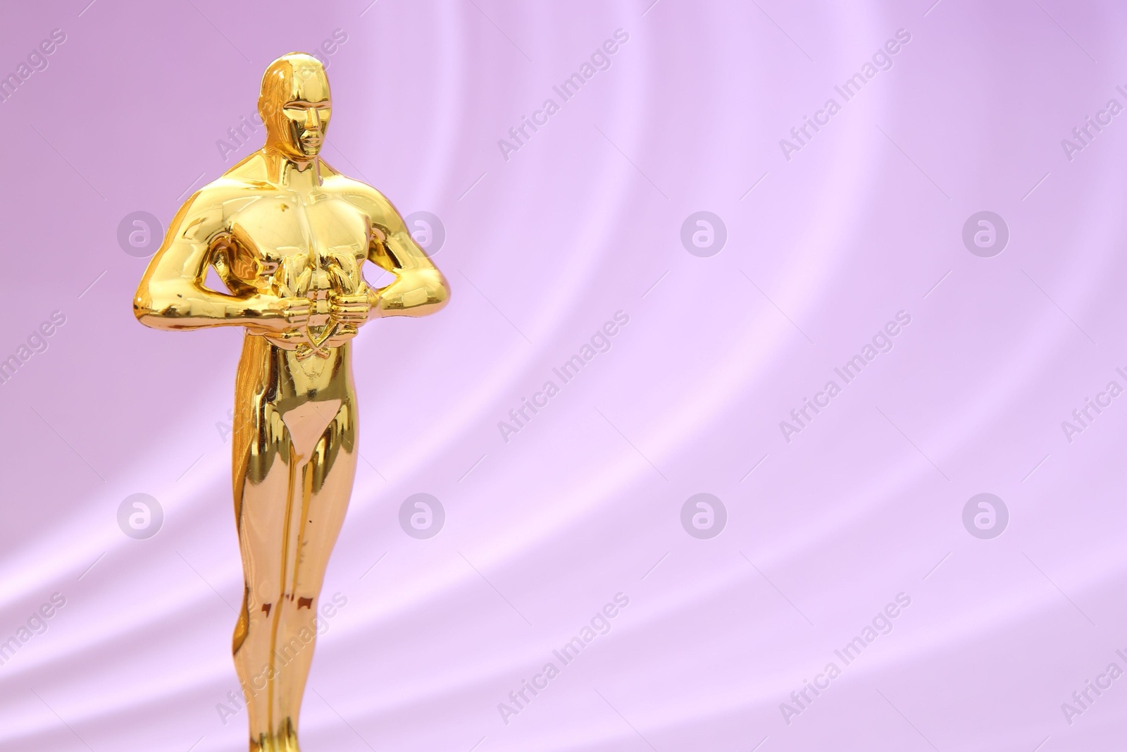 Photo of One golden Oscar award on violet background, space for text