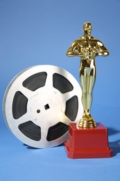 Photo of Golden Oscar award and film reel on light blue background