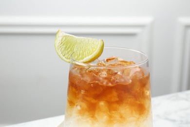 Refreshing espresso tonic drink with slice of lime on table, closeup