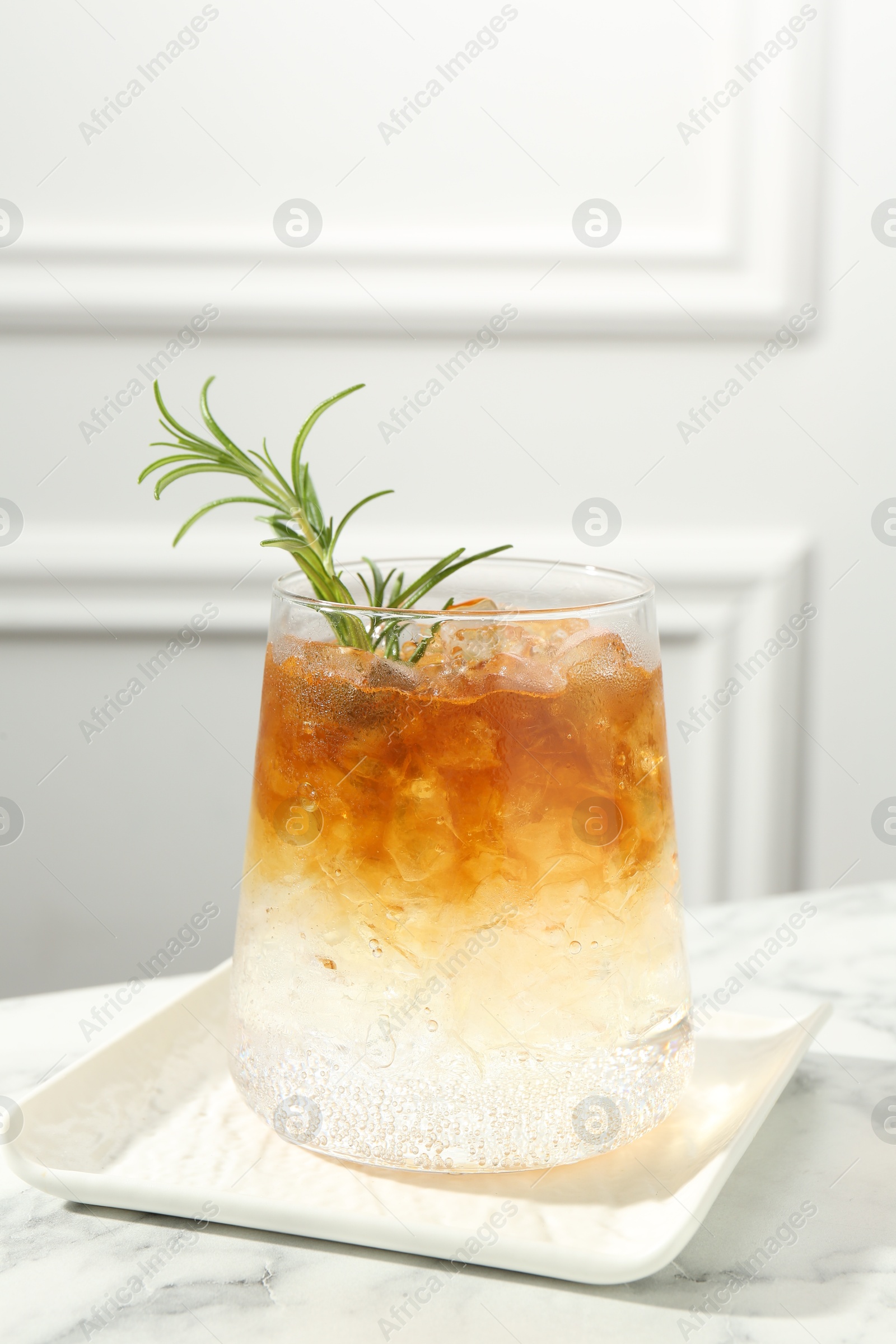 Photo of Refreshing espresso tonic drink with rosemary on white marble table