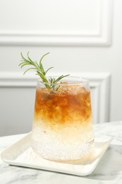 Photo of Refreshing espresso tonic drink with rosemary on white marble table