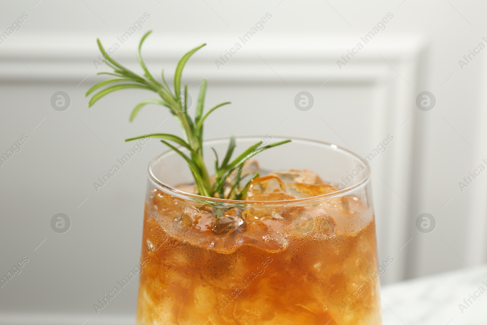 Photo of Refreshing espresso tonic drink with rosemary on blurred background, closeup