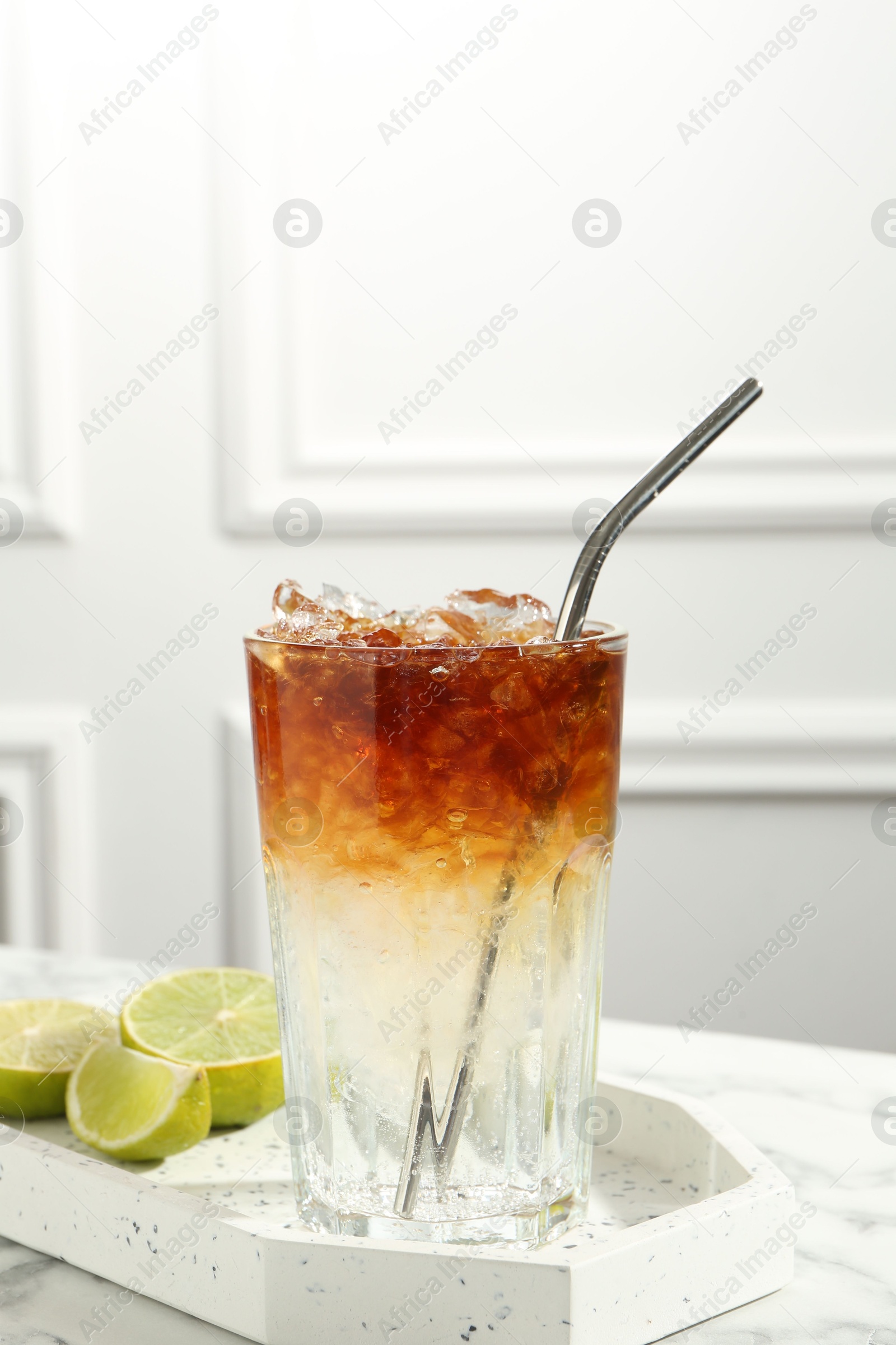 Photo of Refreshing espresso tonic drink and lime on white marble table