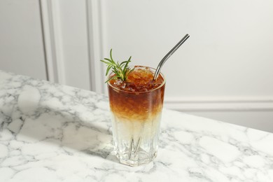 Photo of Refreshing espresso tonic drink with rosemary on white marble table